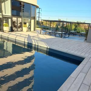 a building with a pool of water next to a building at Torres Brickell Departamento -MALVAN- 1A in Tigre