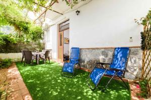 two chairs and a table in a yard with green grass at Casa Grace Amalfi - seaview in Amalfi