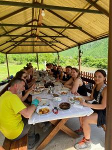 Eine Gruppe von Menschen, die an einem Tisch sitzen und Essen essen. in der Unterkunft Driti GH Nderlysa in Shkodra