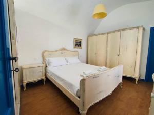 - une chambre avec un lit blanc et une tête de lit en bois dans l'établissement Homiday - La Casa di Nonno Baffo, à Silvi Paese