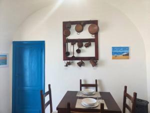 une salle à manger avec une table et une porte bleue dans l'établissement Homiday - La Casa di Nonno Baffo, à Silvi Paese