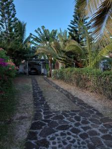 a cobblestone path in front of a house with palm trees at Blue Paradise in Blue Bay