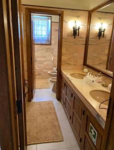 een badkamer met 2 wastafels, een spiegel en 2 toiletten bij Casa Mata da Ribeira in Barcelos