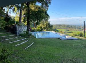 a swimming pool in a yard with some stairs at Casa Mata da Ribeira in Barcelos