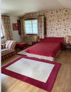 1 dormitorio con cama roja y alfombra roja y blanca en Casa Mata da Ribeira, en Barcelos