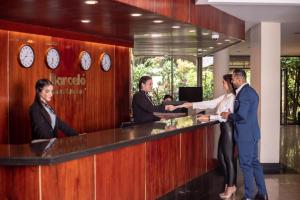 un grupo de personas de pie en un mostrador de recepción en Barceló San José, en San José