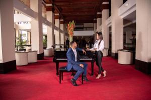 un homme et une femme assis au piano dans l'établissement Barceló San José, à San José