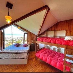 a bedroom with two beds with red cushions at Patagonia Nice View in Puerto Montt