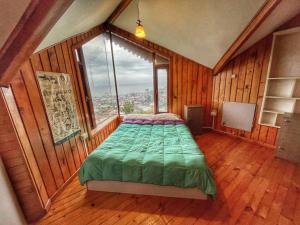 1 dormitorio con 1 cama en una habitación con ventana en Patagonia Nice View, en Puerto Montt