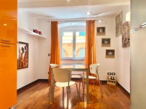 Un comedor con mesa y sillas y una ventana. en CasaViva - Comfy Central Bilo in Genova, en Génova