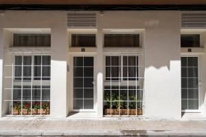 een wit gebouw met ramen en potplanten bij Apartamento boutique estilo Japonés en El Grao Valencia in Valencia