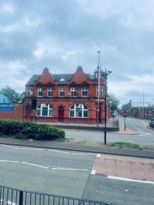 a large red brick building on the corner of a street at 1 bed apartment with 2 beds 1 double plus 1 single in Birmingham