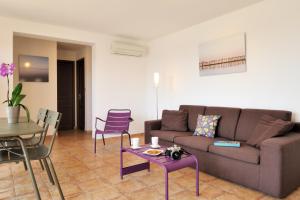 a living room with a couch and a table and chairs at Mini villa Marina Serena in Porto-Vecchio