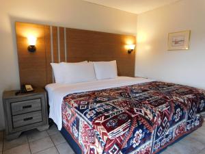 a bedroom with a large bed and a night stand at Drifter Motel in Silver City