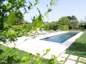 a swimming pool with lounge chairs next to a yard at Podere 43 Charme B&B in Otranto