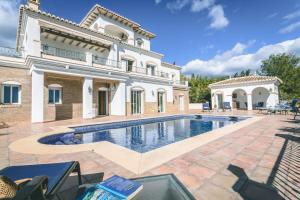 uma casa grande com uma piscina em frente em Casa Miguel em Frigiliana