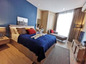 a bedroom with a large bed with a blue wall at Edge Central Pattaya by JJJ in Pattaya Central