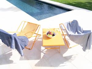 a bowl of fruit sitting on a table next to two chairs at Podere 43 Charme B&B in Otranto