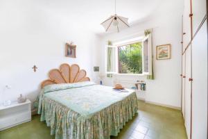 um quarto com uma cama e uma janela em Gli Oleandri di Procchio em Procchio