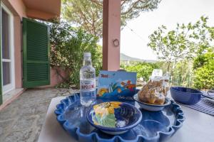 uma mesa com uma garrafa de água e um prato de comida em Gli Oleandri di Procchio em Procchio