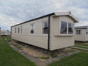 a tiny house is sitting in a yard at Kingfisher : Vacation III:- 6 Berth, Close to site entrance in Ingoldmells
