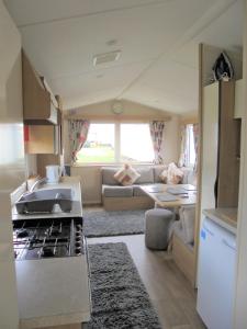 a kitchen and living room of a caravan at Kingfisher : Vacation III:- 6 Berth, Close to site entrance in Ingoldmells