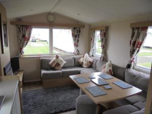 a living room with a couch and a table at Kingfisher : Vacation III:- 6 Berth, Close to site entrance in Ingoldmells