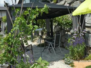 a patio with a table and chairs under a pergola at Haus Harmonie in Millstatt