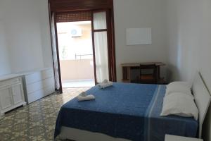 una camera da letto con un letto blu e asciugamani di Lago delle Magnolie Baia Verde a Gallipoli