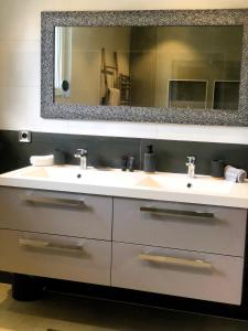 a bathroom with two sinks and a large mirror at Aux Couleurs d'Alsace in Ostwald