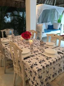 stół z czarno-białą tkaniną stołową z kwiatami w obiekcie Swordfish Villas Samaki House (n.4) w mieście Malindi