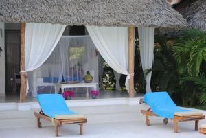 two chairs and a table in front of a resort at Swordfish Villas Samaki House (n.4) in Malindi