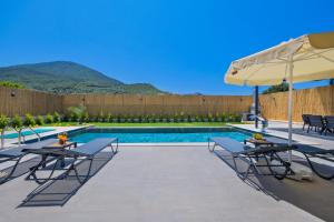 a swimming pool with tables and chairs and an umbrella at Fethiye Villa Ka Exclusive 2 in Fethiye