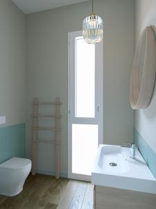 een badkamer met een toilet, een wastafel en een spiegel bij Fenici Levanzo - Island Apartments in Levanzo