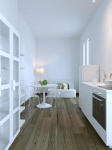 a kitchen with white cabinets and a white table at Fenici Levanzo - Island Apartments in Levanzo