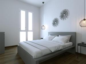 een slaapkamer met een groot bed met witte muren bij Fenici Levanzo - Island Apartments in Levanzo