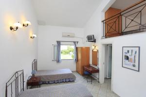 a bedroom with two beds and a mirror and a window at Yiannis Studios in Troulos