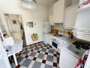 a kitchen with white appliances and a checkered floor at Villa Capucine - Maison de ville avec jardin dans Vernon-Giverny, proche des transports et de la gare in Vernon