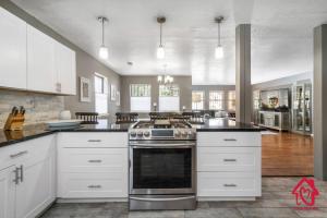uma cozinha com armários brancos e um fogão em Casa Bonita - An Irvie Home em Albuquerque