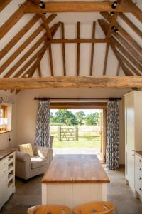 uma sala de estar com uma mesa de madeira e um sofá em The Cowshed em Hooe