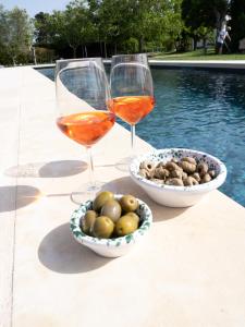 two glasses of wine next to a bowl of olives and a bowl of nuts at Podere 43 Charme B&B in Otranto