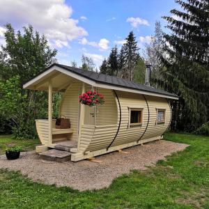 a large shed with a porch and a flower pot at Suopirtti bed & breakfast in Konnevesi