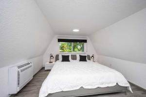 a white bedroom with a large bed and a window at Sumner Lake Tiny House in Clermont