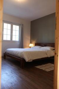ein Schlafzimmer mit einem großen Bett und einem Fenster in der Unterkunft Fleurs de Brenne Gite in Neuillé-le-Lierre