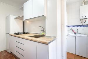 a kitchen with white cabinets and a sink at Trendy Homes Zapillo I - Playa a 5 minutos andando in Almería