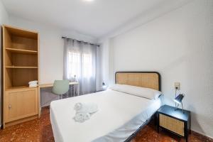 1 dormitorio con 1 cama blanca grande y escritorio en Trendy Homes Zapillo I - Playa a 5 minutos andando en Almería