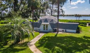 a small house with a gambrel roof in a yard at Sumner Lake Tiny House in Clermont