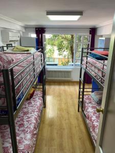 a room with three bunk beds and a window at Hostal Madrid Paradise in Madrid