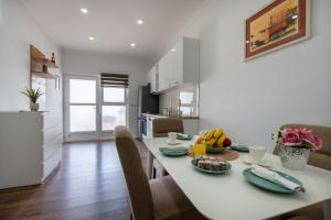 uma cozinha e sala de jantar com uma mesa branca e cadeiras em Ivano em Ston