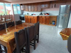 uma cozinha com armários de madeira e uma mesa com cadeiras em Hospedaje Barato Mi Casita de Colores em Tijuana